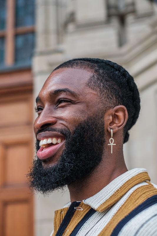 man in white and brown striped shirt smiling